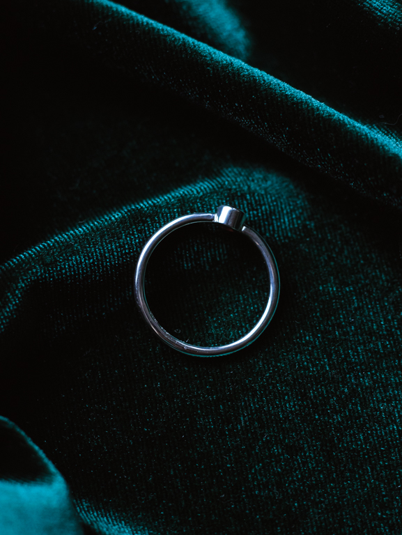 Sormus punaisella kivellä